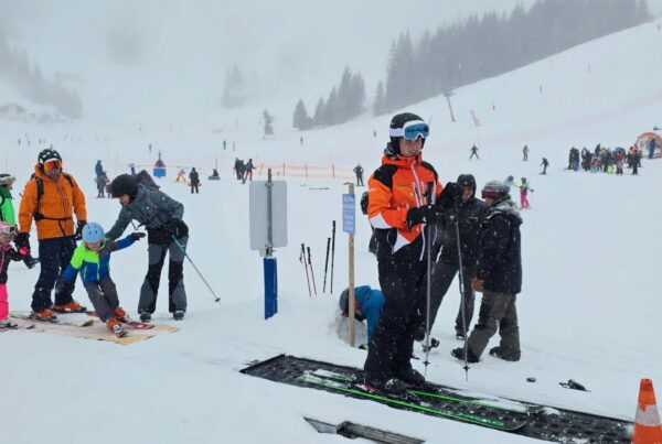 Children attending ski school in Austria with parents next to them looking