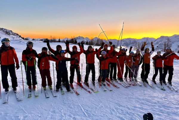 group photo of our big ski school class with georgeous sunset in Hinterstoder Alps in the background