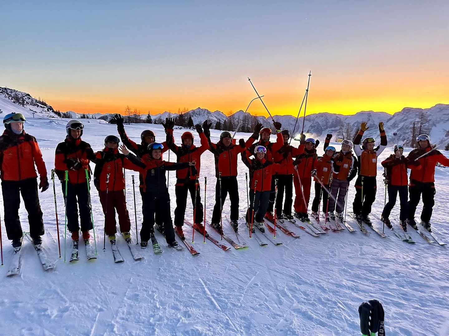 group photo of our big ski school class with georgeous sunset in Hinterstoder Alps in the background