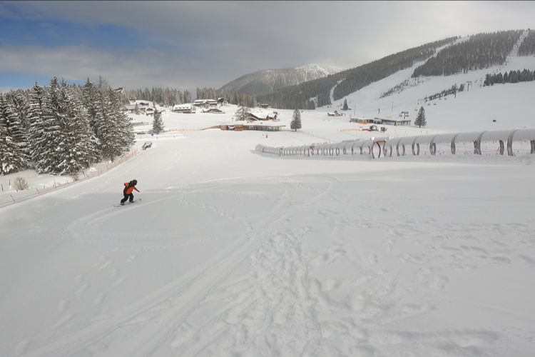 leere Piste im Kinderland mit Snowboarder