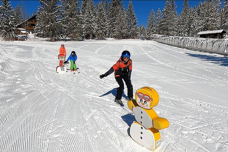 Kinderskikurs im Kinderland - abklatschen bei Schneemannfigur