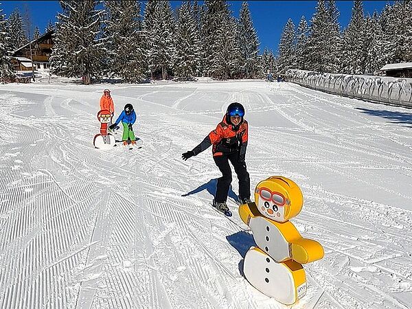 Kinderskikurs im Kinderland - abklatschen bei Schneemannfigur